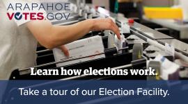 A man handles ballots inside the Arapahoe County Elections Facility