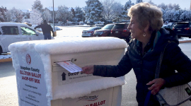 Marilyn Fenner drops her ballot off on her way to work as an election judge